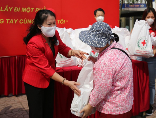 Chủ tịch Hội Chữ thập đỏ Việt Nam Nguyễn Thị Xuân Thu trao quà cho các hộ dân bị ảnh hưởng bởi dịch Covid-19.